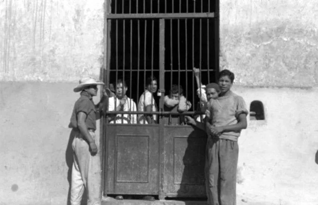 Men crowd behind barred gates in a Mexican prison in 1935.
